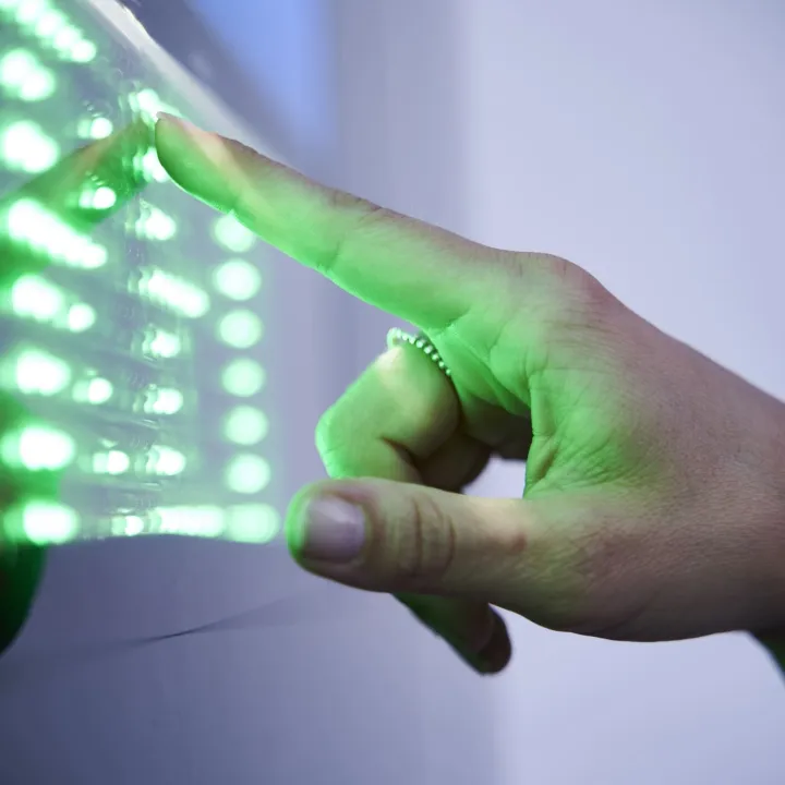 Detalle de una tira de LED encendida junto a una mano